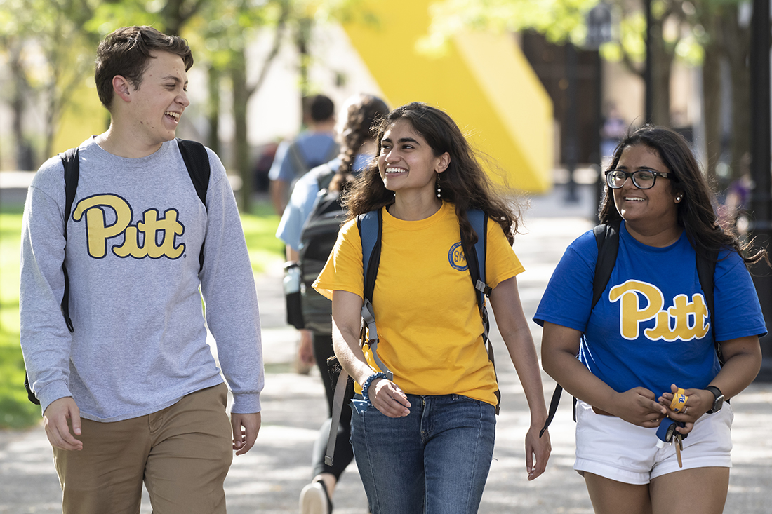 three Pitt students walking on campus